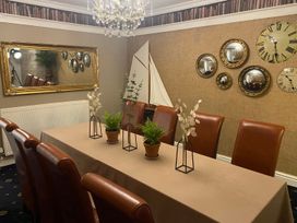 A dining room with a table and chairs at Lonsdale House in Bowness-On-Windermere