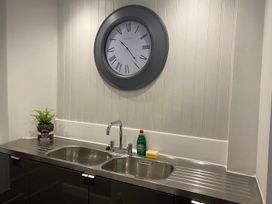 A kitchen with a sink and clock at Lonsdale House Bowness-On-Windermere