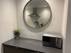 A kitchen with a microwave and a plant at Lonsdale House Bowness-On-Windermere