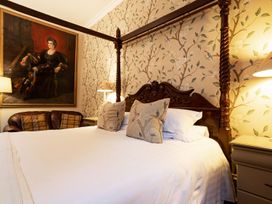 A bedroom with a four-poster bed and wall art at Lonsdale House Bowness-On-Windermere