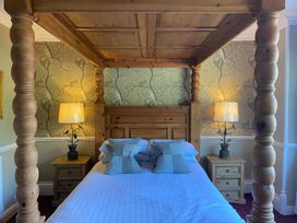 A bedroom with a four-poster bed and bedside tables at Lonsdale House, Bowness-On-Windermere