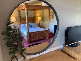 A bedroom with a four-poster bed and a television at Lonsdale House in Bowness-On-Windermere
