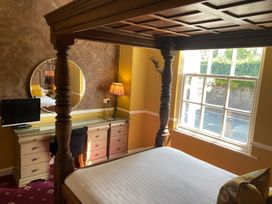 A bedroom with a four-poster bed and desk at Lonsdale House Bowness-On-Windermere