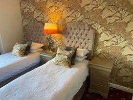 A bedroom with twin beds and a lamp at Lonsdale House Bowness-On-Windermere
