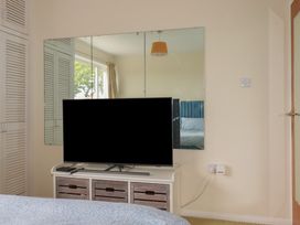 A bedroom featuring a television on a dresser and a mirror on the wall at 7 Chycoose Parc 