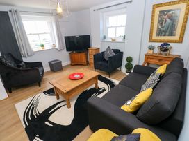 A living room with a sofa, armchairs and a coffee table at Newgale Cottage in Haverfordwest