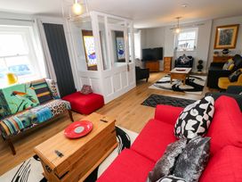 A living room with a sofa, coffee table and television at Newgale Cottage in Haverfordwest