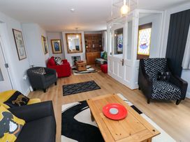 A living room with a coffee table and seating areas at Newgale Cottage in Haverfordwest