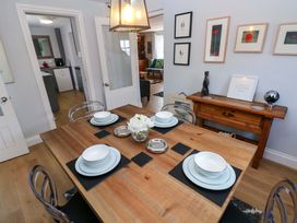 A dining room with a wooden table set for dinner at Newgale Cottage in Haverfordwest