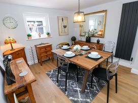 A dining room with a table set for dinner at Newgale Cottage in Haverfordwest