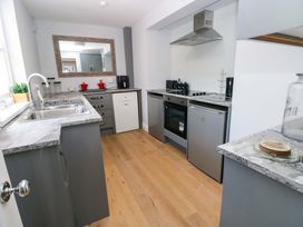 A kitchen with appliances and countertops at Newgale Cottage in Haverfordwest
