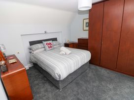 A bedroom with a bed and wardrobe at Newgale Cottage in Haverfordwest