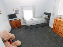 A bedroom with a bed and television at Newgale Cottage Haverfordwest