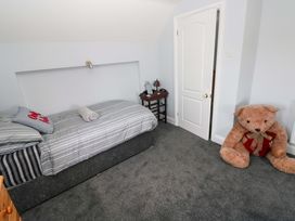 A bedroom with a bed and a teddy bear at Newgale Cottage in Haverfordwest