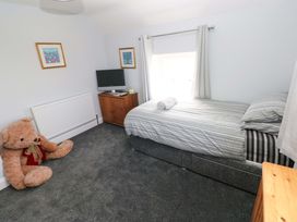 A bedroom with a bed and television at Newgale Cottage in Haverfordwest