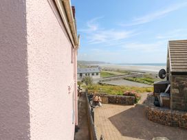 An outdoor area with a pink wall and a view of the sea at Newgale Cottage in Newgale