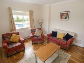 A living room with a sofa and armchairs at River House
