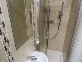 A shower with a glass door and a mirror in a bathroom at River House