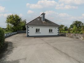 A house with a driveway and trees at River House