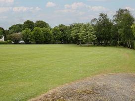 A grassy area with trees and a path at River House in 