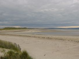 A beach with sand and water in the distance at River House