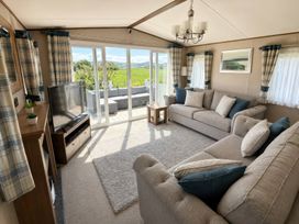 A living room with a sofa and television at Caravan i35 in Conwy