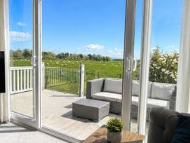 A living room with a view of grass and sheep at Caravan i35 in Conwy