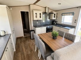 A kitchen with a table and chairs at Caravan i35 in Conwy