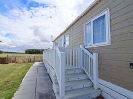 A caravan exterior with steps and grass at Caravan i35 in Towyn