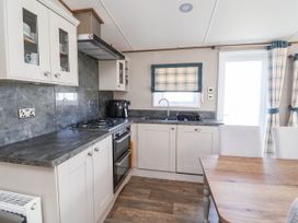 A kitchen with a stove and sink at Caravan i35 Towyn