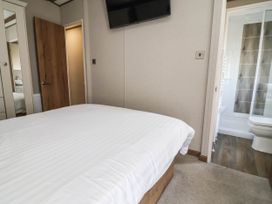 A bedroom with a bed and attached bathroom at Caravan i35 in Towyn