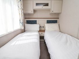 A bedroom with two beds and a window at Caravan i35 in Towyn