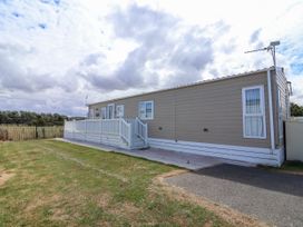 A caravan with a deck and steps at Caravan i35 Towyn