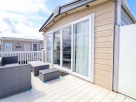 An outdoor patio with chairs and a table at Caravan i35 in Towyn