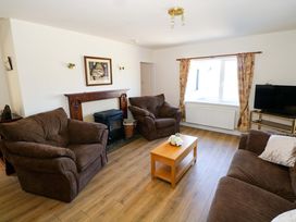 A living room with a sofa, coffee table, and fireplace at Cahir Cottage in Ballinrobe, County Mayo
