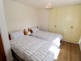 A bedroom with two single beds and a wardrobe at Cahir Cottage, Ballinrobe, County Mayo