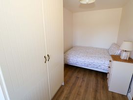 A bedroom with a bed and wardrobe at Cahir Cottage in Ballinrobe, County Mayo