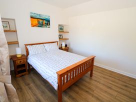 A bedroom with a bed and nightstand at Cahir Cottage in Ballinrobe, County Mayo