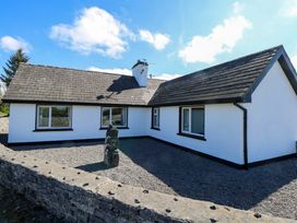 A house with gravel and a stone wall at Cahir Cottage in Ballinrobe, County Mayo