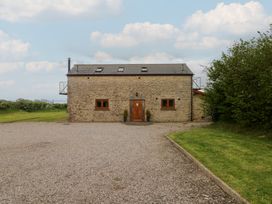 A stone building with a gravel driveway at The Gallops in Barry