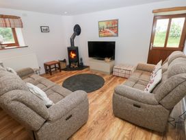 A living room with a sofa, rug, and television at The Gallops in Barry