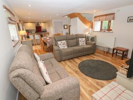 A living room with seating and a dining area at The Gallops in Barry