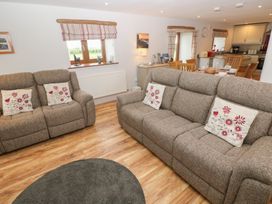 A living room with sofas and dining area at The Gallops in Barry