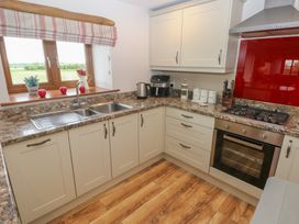 A kitchen with a sink and cupboards at The Gallops in Barry