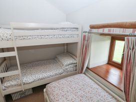 A bedroom with a bunk bed and single bed at The Gallops in Barry