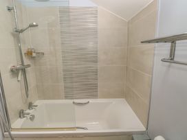 A bathroom with a shower over a bathtub at The Gallops in Barry