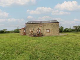 A house with a table and chairs on grass at The Gallops in Barry