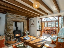 A living room with a fireplace and wooden table at Trehaverock Cottage in St. Endellion near Port Isaac