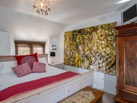 A bedroom with a bed and wall art at Trehaverock Cottage St. Endellion near Port Isaac