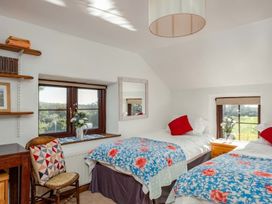 A bedroom with two beds and a bookshelf at Trehaverock Cottage St. Endellion near Port Isaac